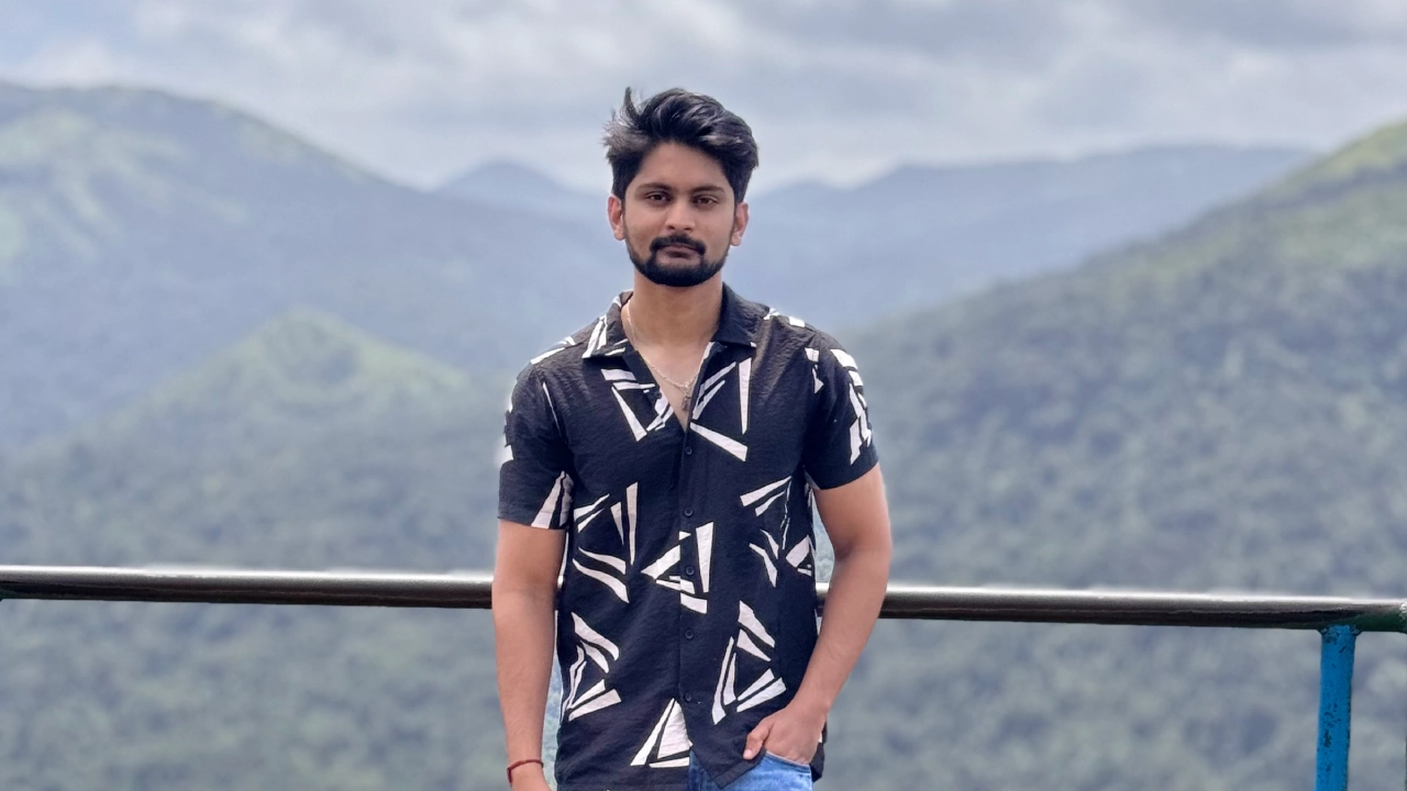 Amar Karthik standing on top of a hill viewpoint